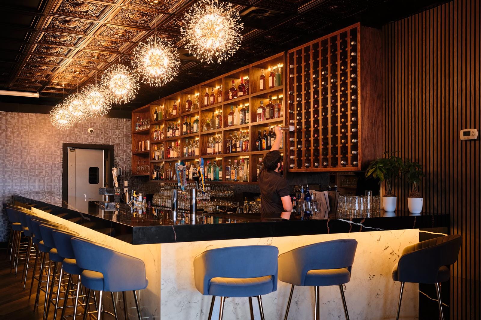 Aldie Biryani Grill bar with firework pendants and backlit spirit wall