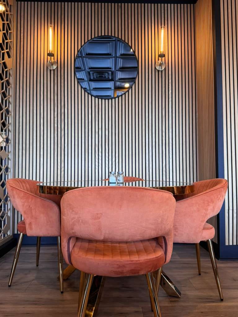 Chantilly Biryani Grill intimate seating with round mirror and sconce lights